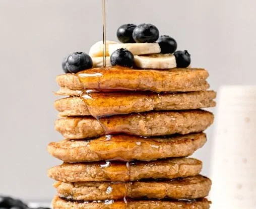 Stack of delicious Blender Protein Oatmeal Pancakes with syrup and berries