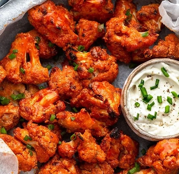 Crispy Buffalo Cauliflower Wings served with dipping sauce on a plate.