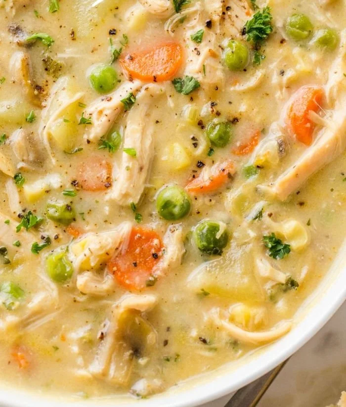 Bowl of creamy chicken pot pie soup garnished with herbs