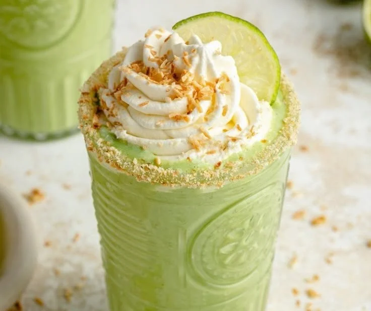 Coconut Key Lime Pie Smoothie in a glass with lime and coconut garnish
