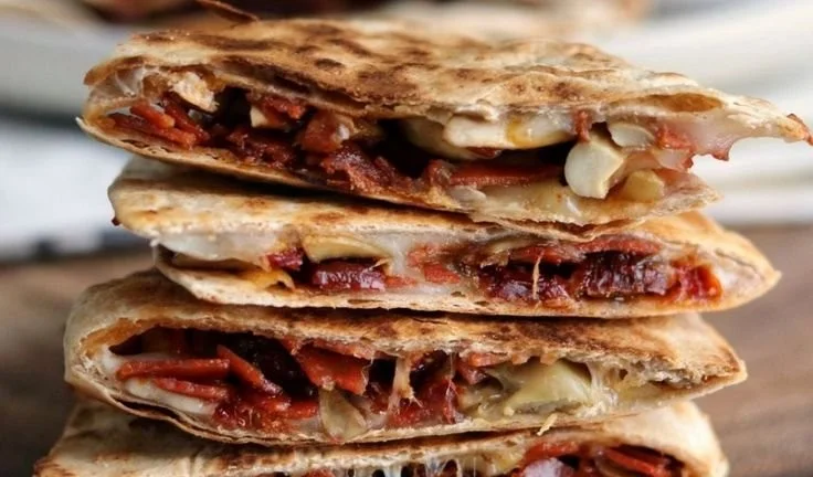 Cheesy Pizza Quesadillas garnished with herbs and served on a plate