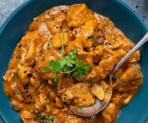 Delicious slow cooker chicken curry in a bowl, garnished with cilantro and spices.