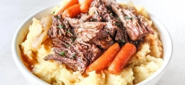 Delicious slow cooker pot roast with garlic and herbs served on a plate