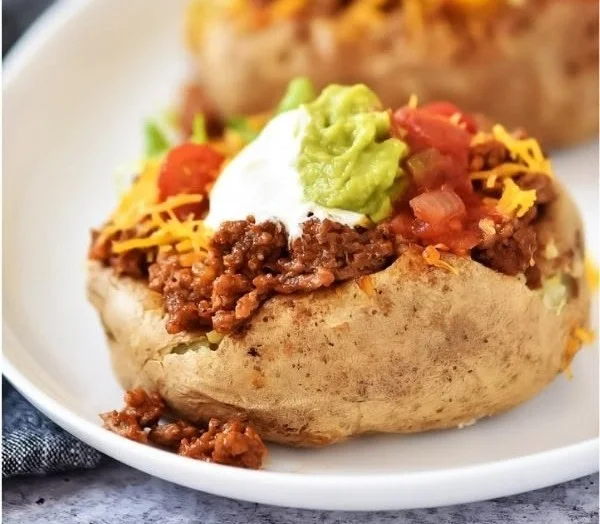 Delicious taco potatoes topped with cheese and salsa, served on a plate.
