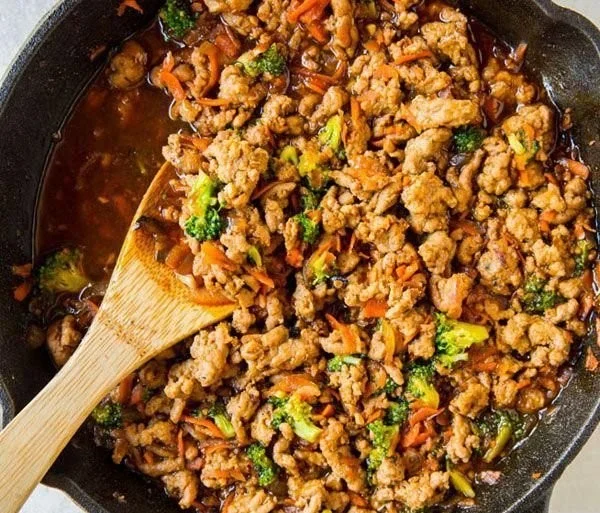 Healthy teriyaki turkey rice bowl with vegetables and garnishes